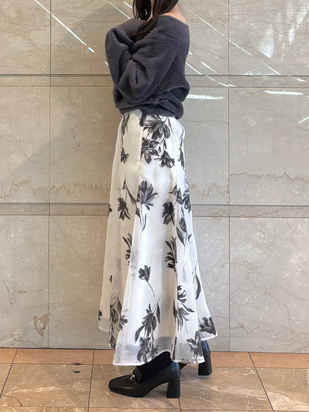 ホワイト系のスカート、ブラック系のブーツ、グレー系のニット/セーターを着用したレディースの冬コーディネートの2枚目の写真