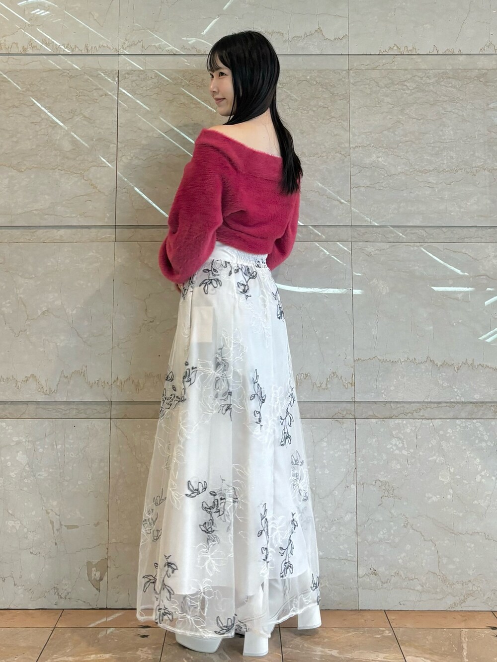 ホワイト系のブーツ、ホワイト系のスカート、レッド系のニット/セーターを着用したレディースの秋コーディネートの2枚目の写真