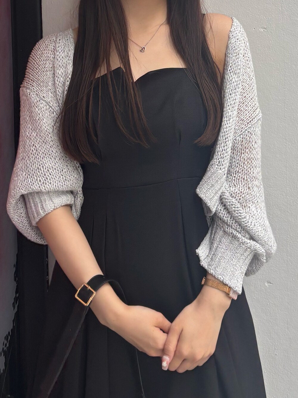 ブラック系のワンピース、ホワイト系のサンダル、ブラック系のハンドバッグを着用したレディースの夏コーディネートの6枚目の写真