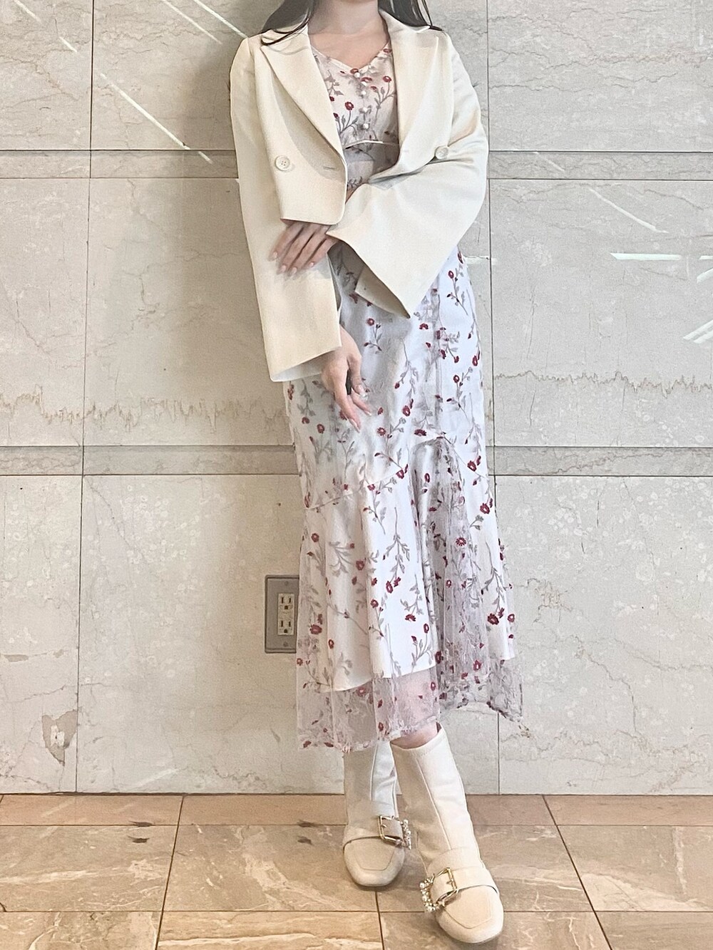 レッド系のワンピース、ホワイト系のブーツ、ホワイト系のテーラードジャケットを着用したレディースの春コーディネートの2枚目の写真