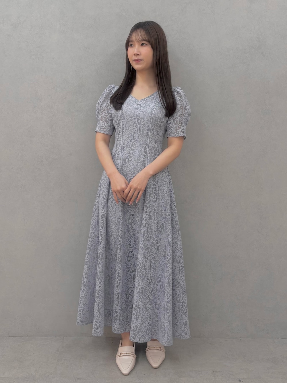 ブルー系のワンピース、ホワイト系のパンプスを着用したレディースの冬コーディネートの2枚目の写真