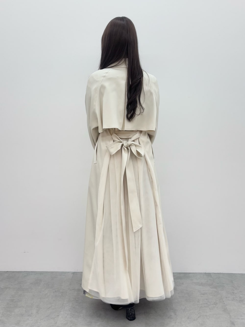 ブラック系のブーツ、グレー系のニット/セーター、ホワイト系のトレンチコートを着用したレディースの冬コーディネートの4枚目の写真