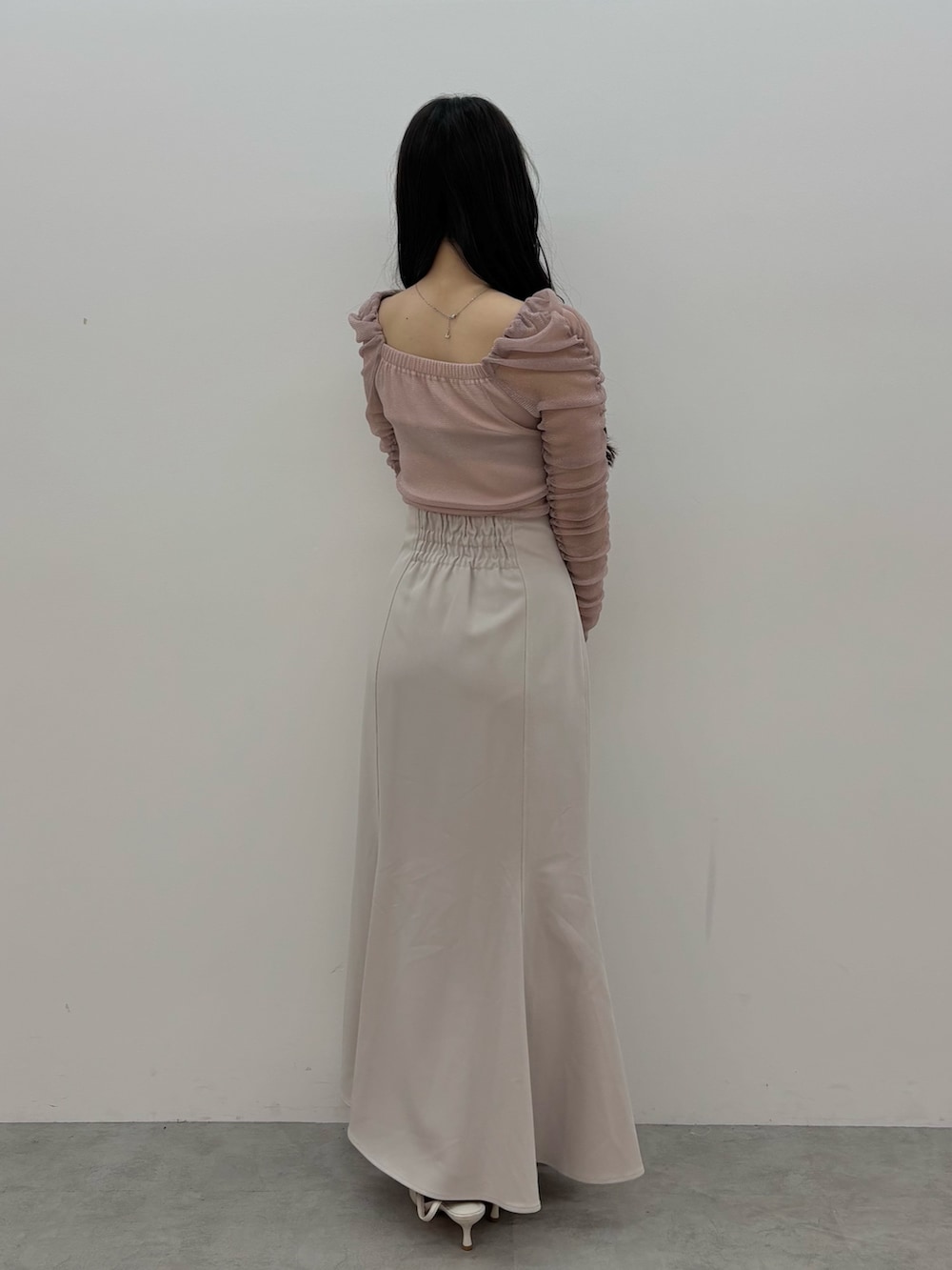 グレー系のスカート、ピンク系のTシャツ/カットソー、ホワイト系のパンプスを着用したレディースの夏コーディネートの3枚目の写真