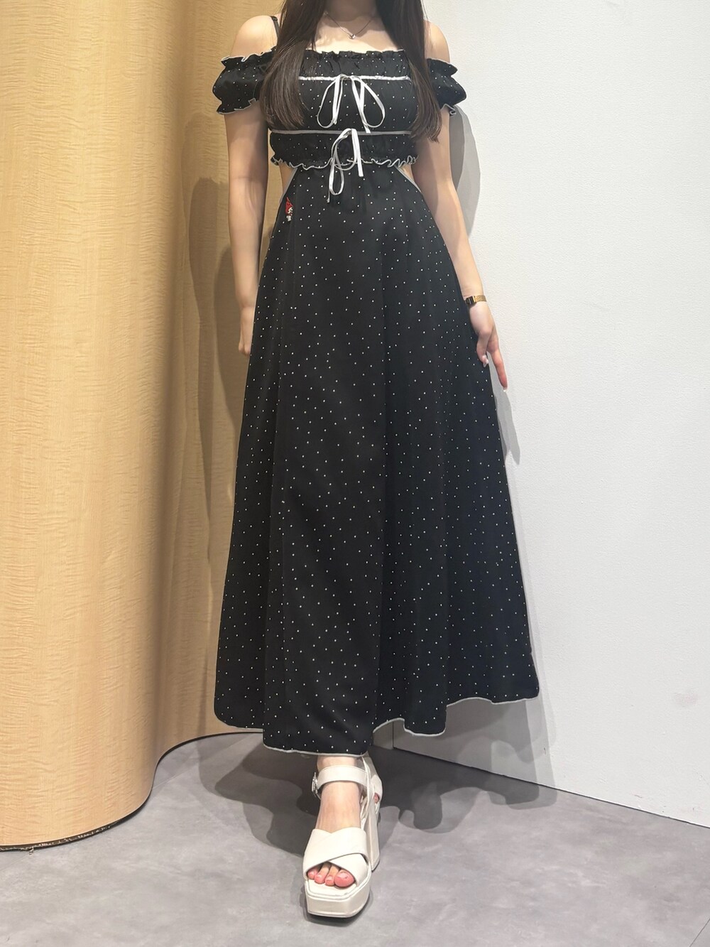 ホワイト系のサンダル、ブラック系のワンピースを着用したレディースの夏コーディネートの6枚目の写真