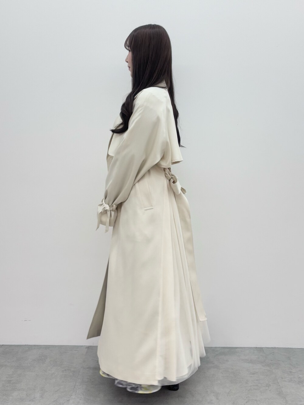 ブラック系のブーツ、グレー系のニット/セーター、ホワイト系のトレンチコートを着用したレディースの冬コーディネートの3枚目の写真