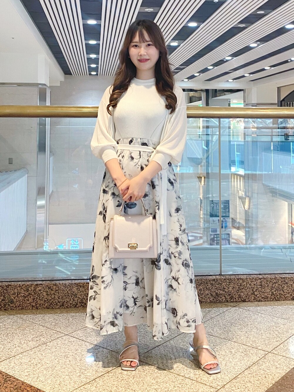 ホワイト系のワンピース、シルバー系のサンダル、ホワイト系のカーディガン/ボレロを着用したレディースの夏コーディネートの2枚目の写真