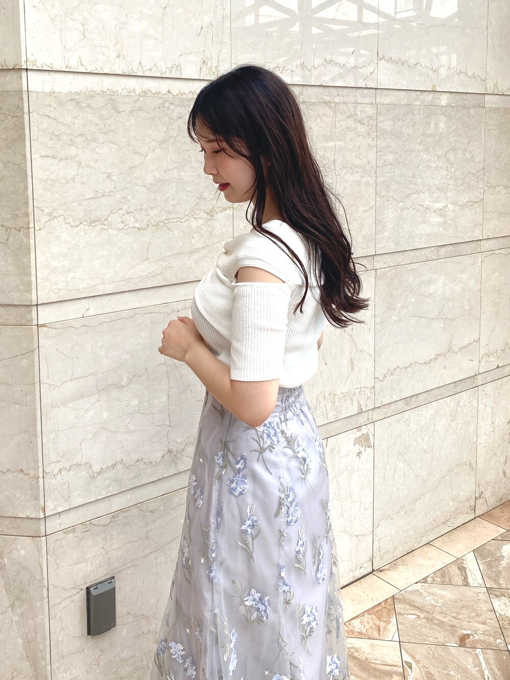 ホワイト系のニット/セーター、ブルー系のスカート、ホワイト系のブーツを着用したレディースの夏コーディネートの6枚目の写真