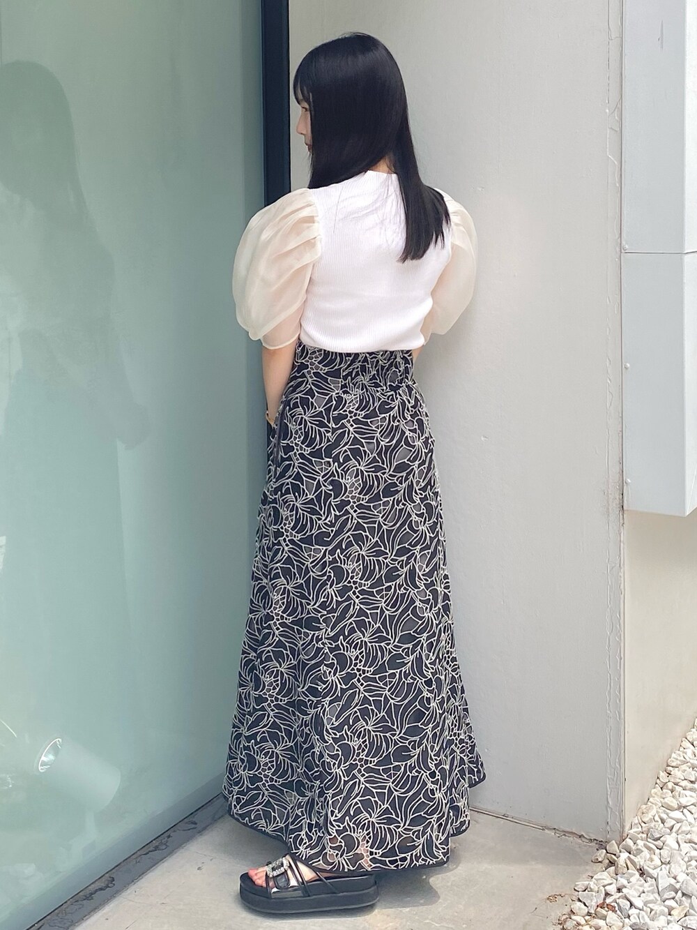 ブラック系のサンダル、ホワイト系のニット/セーター、ブラック系のスカートを着用したレディースの夏コーディネートの4枚目の写真