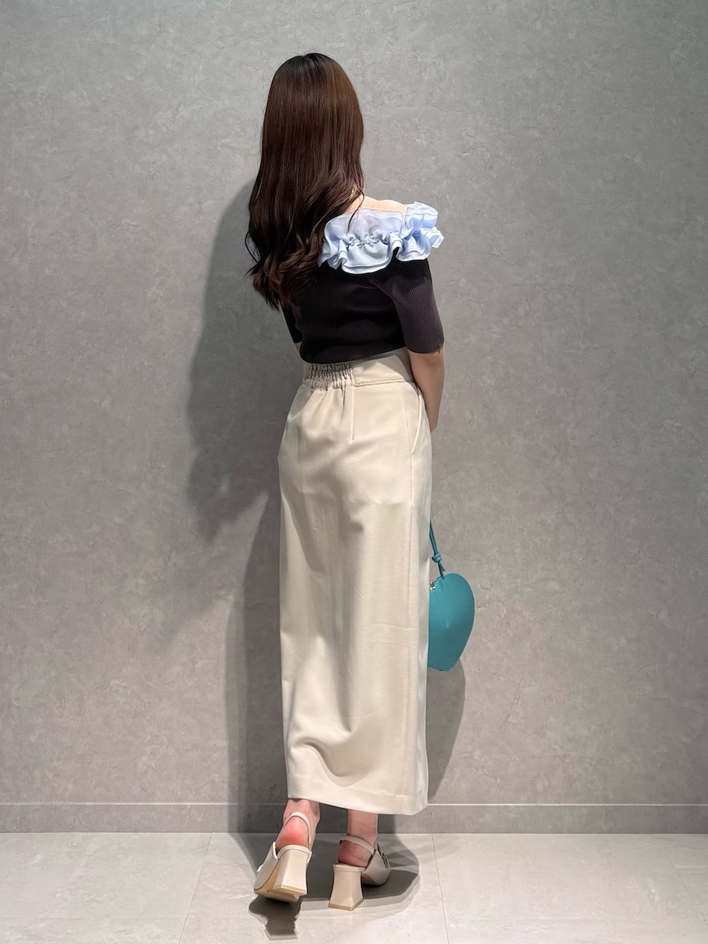 ホワイト系のスカート、グレー系のニット/セーター、グリーン系のショルダーバッグを着用したレディースの春コーディネートの5枚目の写真