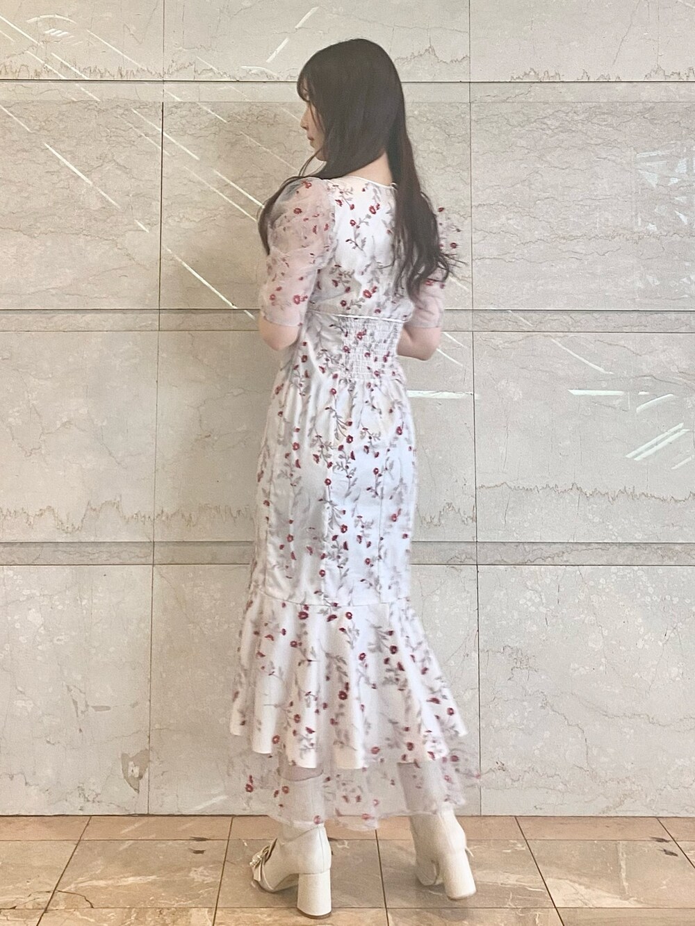 レッド系のワンピース、ホワイト系のブーツを着用したレディースの春コーディネートの3枚目の写真