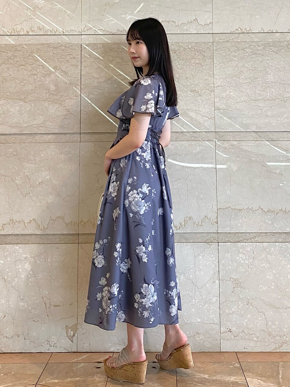 ホワイト系のハンドバッグ、グレー系のワンピース、その他のサンダルを着用したレディースの夏コーディネートの2枚目の写真