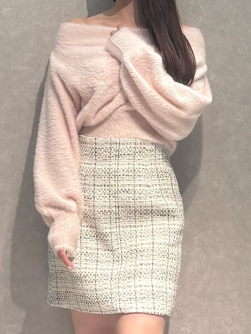 ホワイト系のスカート、ピンク系のニット/セーター、ブラック系のブーツを着用したレディースの秋コーディネートの3枚目の写真