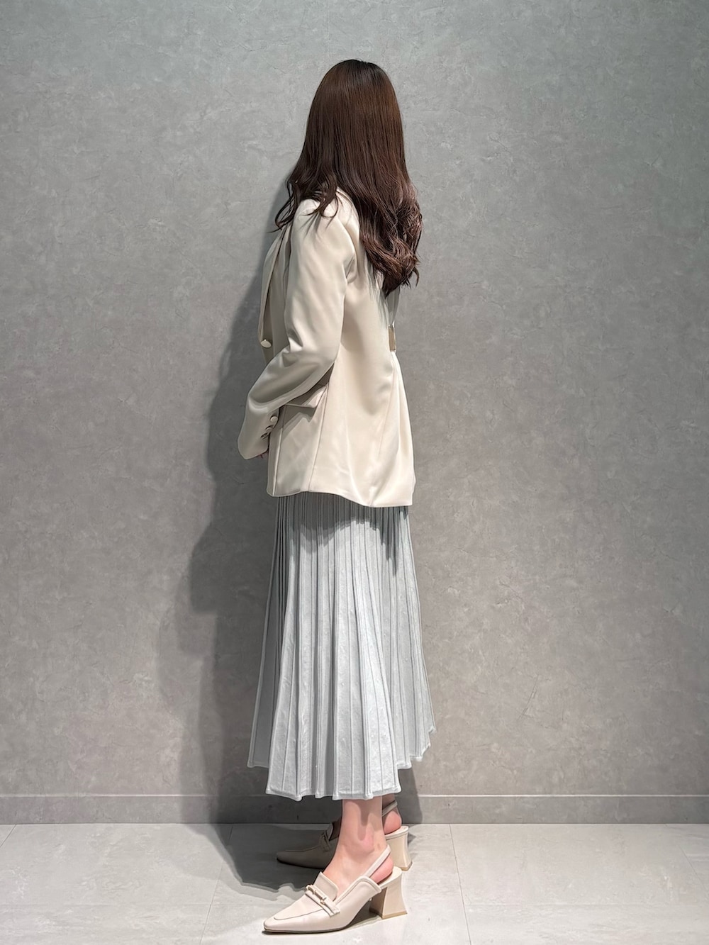 グレー系のワンピース、ホワイト系のテーラードジャケット、ホワイト系のパンプスを着用したレディースの春コーディネートの4枚目の写真