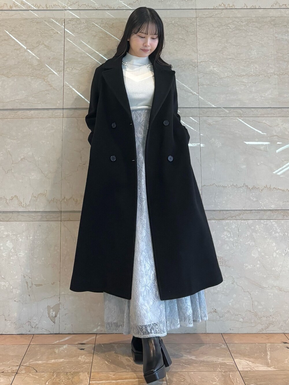 ブルー系のスカート、ブラック系のブーツ、ホワイト系のニット/セーターを着用したレディースの冬コーディネートの5枚目の写真