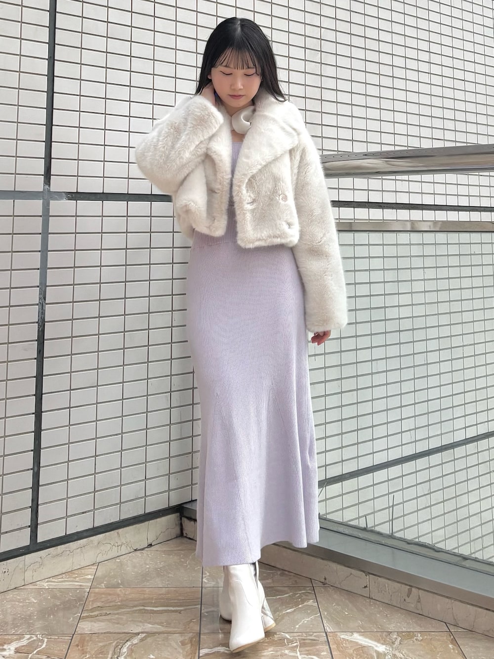 パープル系のワンピース、ホワイト系のブーツ、ホワイト系のその他アウターを着用したレディースの冬コーディネートの2枚目の写真