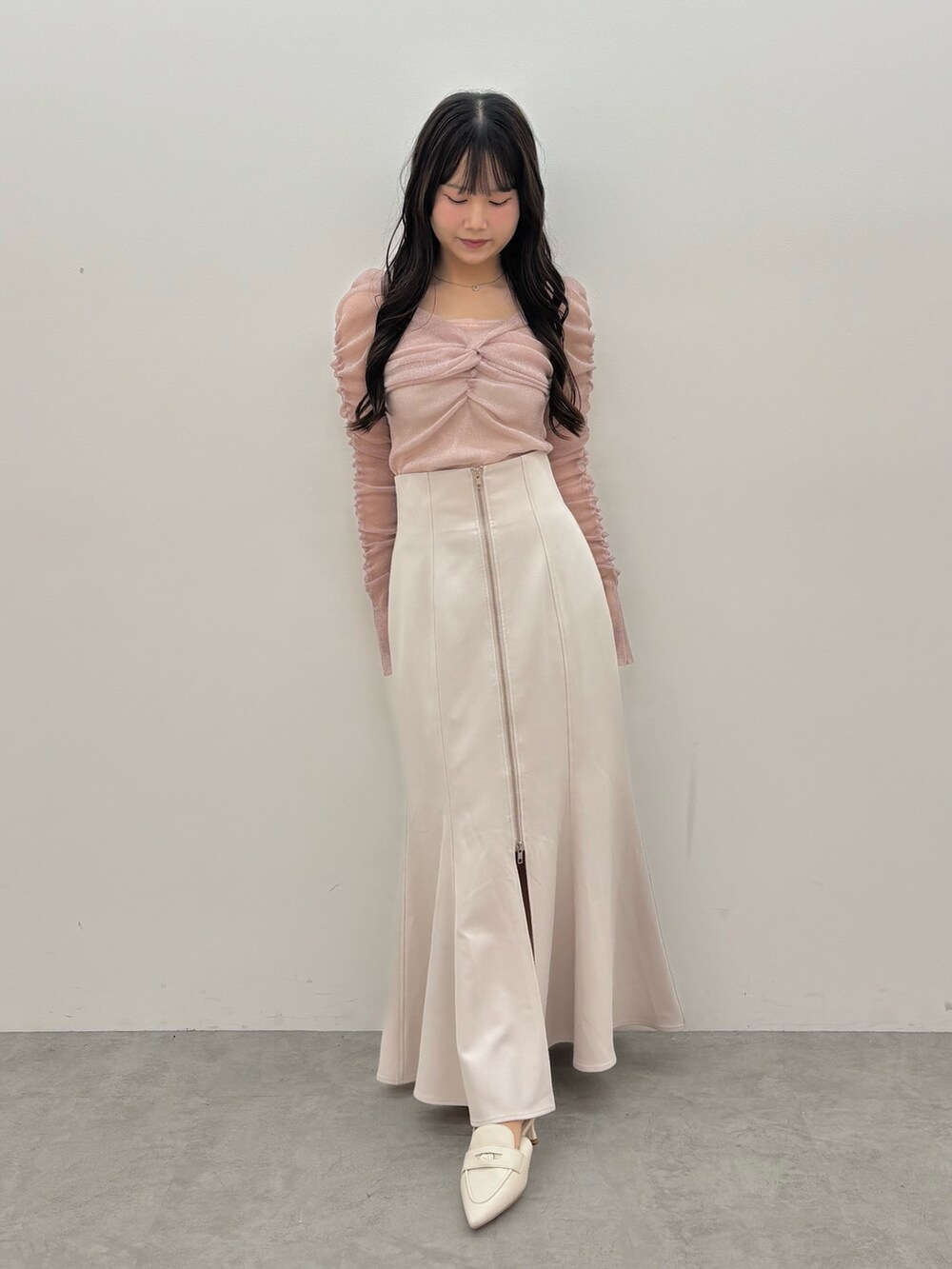 グレー系のスカート、ピンク系のTシャツ/カットソー、ホワイト系のパンプスを着用したレディースの夏コーディネートの2枚目の写真