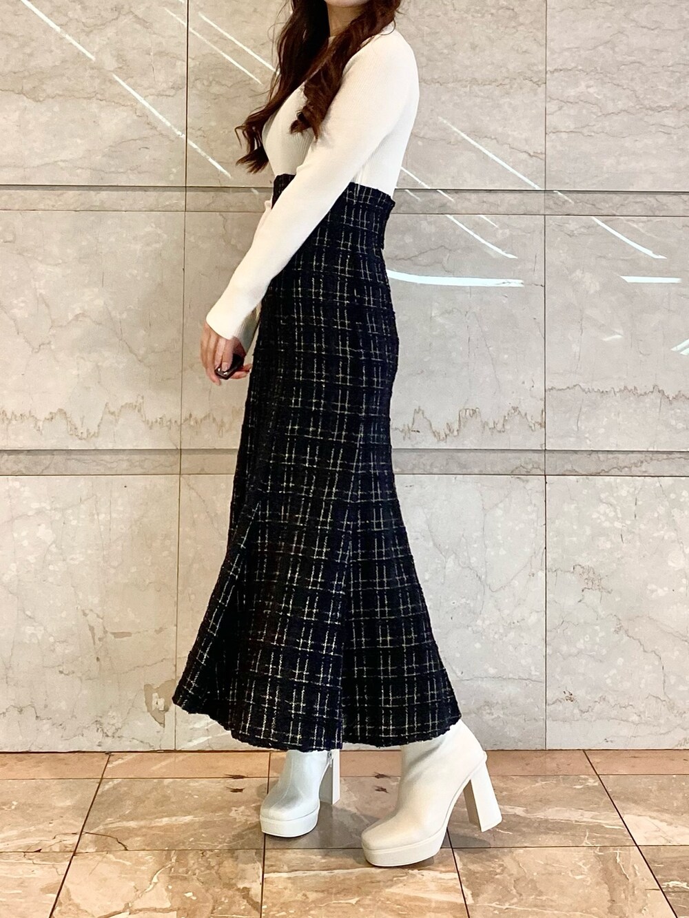 ブラック系のワンピース、ホワイト系のブーツを着用したレディースの秋コーディネートの3枚目の写真