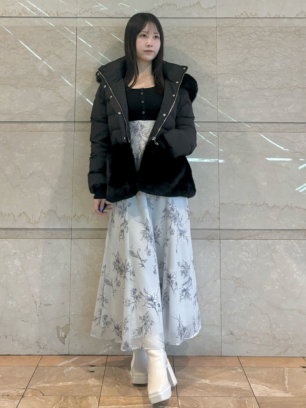 ブラック系のワンピース、ホワイト系のブーツ、ブラック系のその他アウターを着用したレディースの秋コーディネートの2枚目の写真