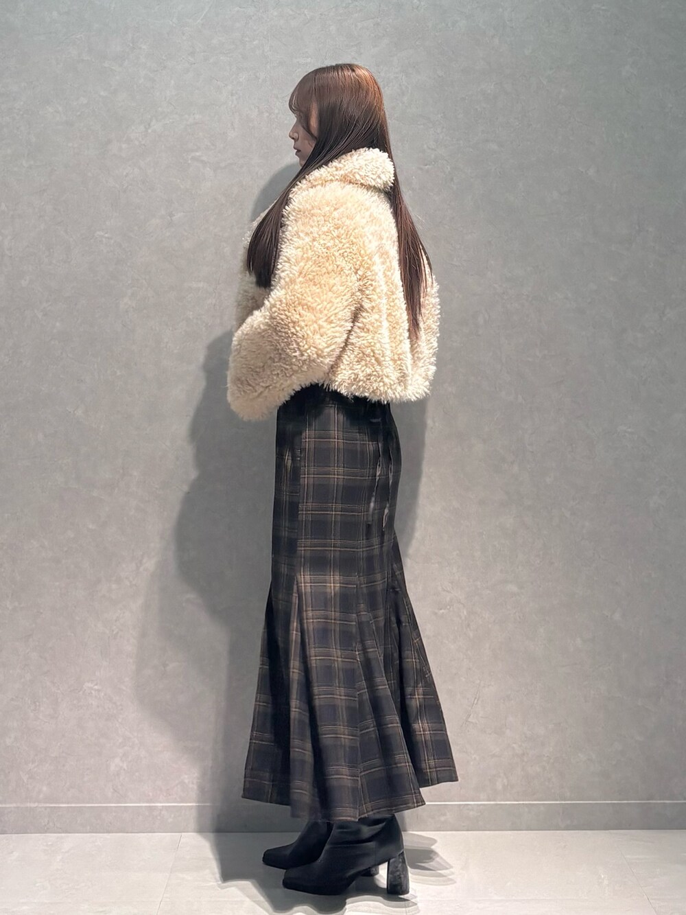 ブラウン系のスカート、ホワイト系のニット/セーター、ベージュ系のその他アウターを着用したレディースの秋コーディネートの4枚目の写真