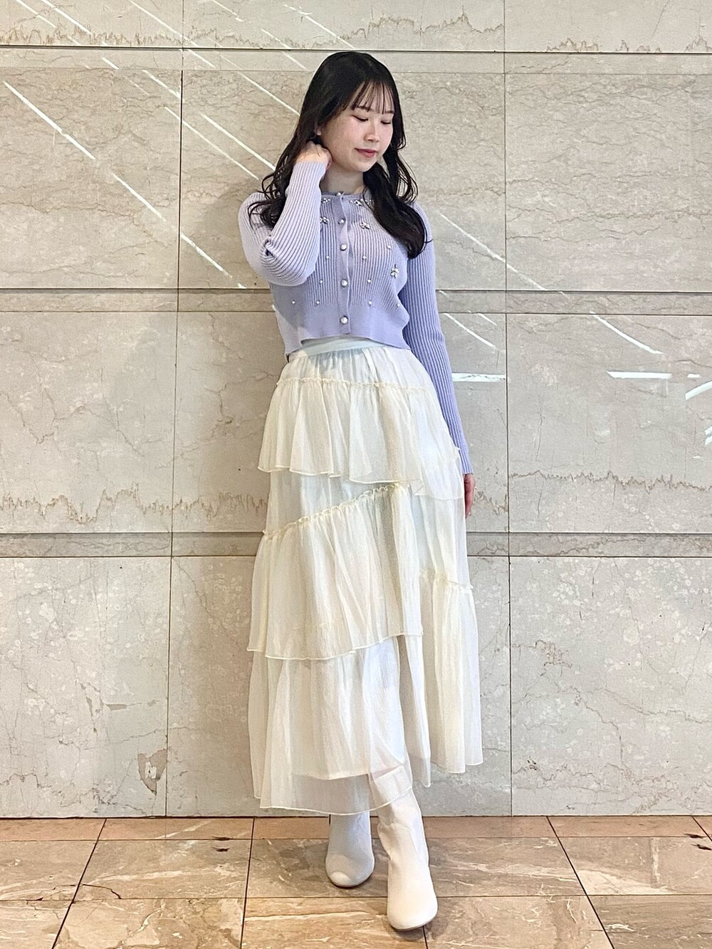 ブルー系のカーディガン/ボレロ、ホワイト系のスカート、ホワイト系のブーツを着用したレディースの冬コーディネートの4枚目の写真