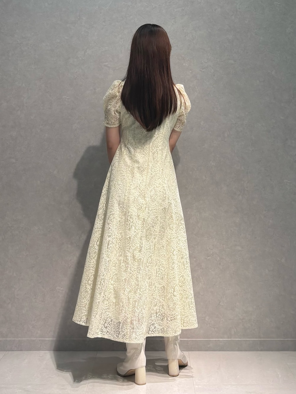 ホワイト系のブーツ、ブラウン系のハンドバッグ、イエロー系のワンピースを着用したレディースの春コーディネートの5枚目の写真