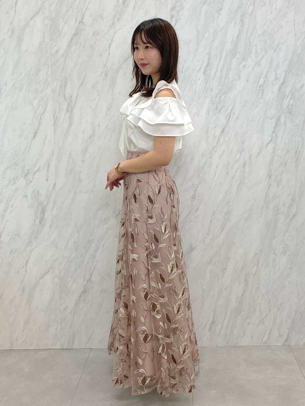 ピンク系のスカート、ホワイト系のシャツ/ブラウス、ホワイト系のパンプスを着用したレディースの夏コーディネートの3枚目の写真