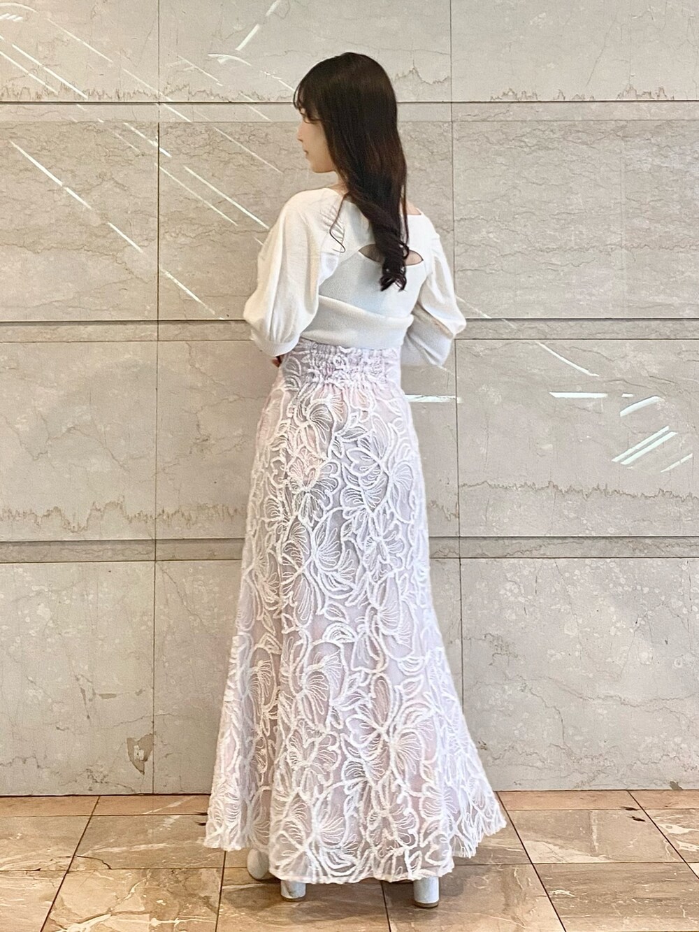 ピンク系のスカート、ホワイト系のブーツ、ホワイト系のニット/セーターを着用したレディースの冬コーディネートの3枚目の写真