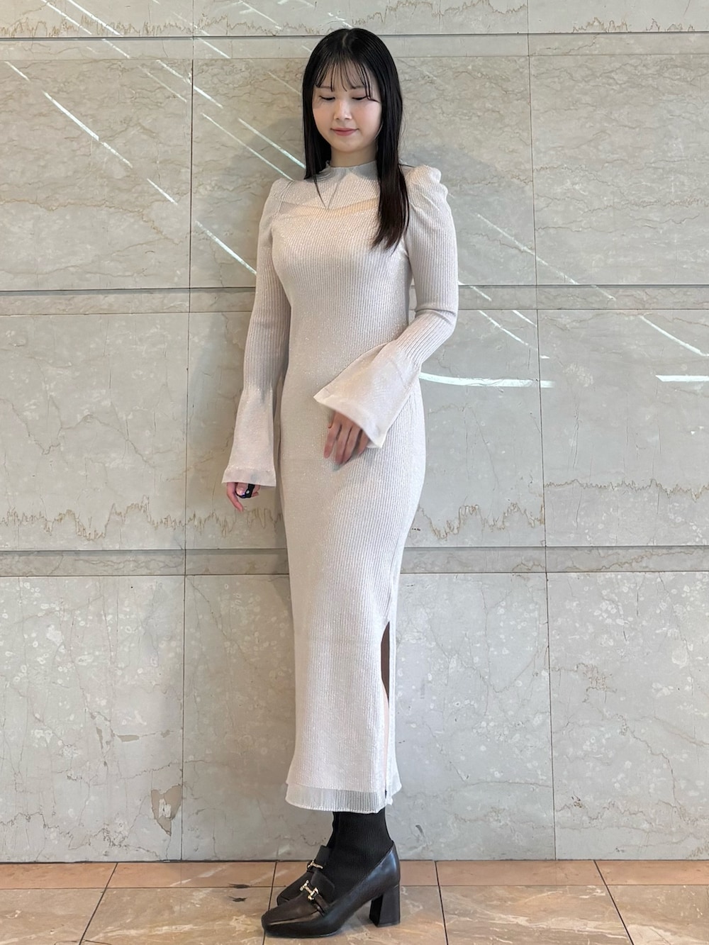 ホワイト系のワンピース、ブラウン系のブーツを着用したレディースの冬コーディネートの3枚目の写真