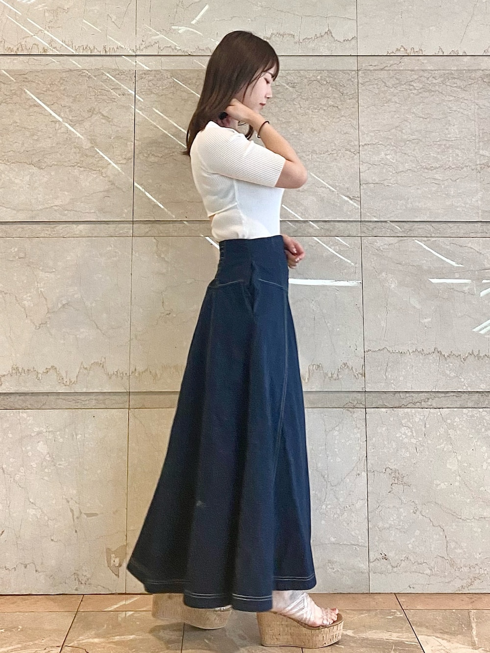 ブルー系のスカート、ホワイト系のニット/セーター、その他のサンダルを着用したレディースの春コーディネートの4枚目の写真