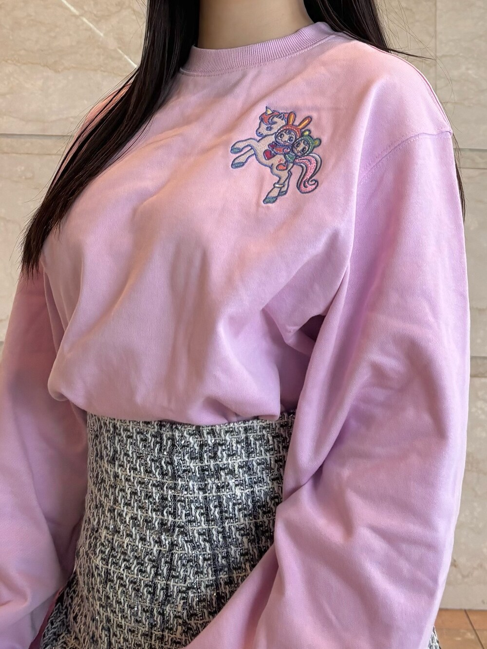 ブラック系のスカート、ホワイト系のブーツ、ピンク系のTシャツ/カットソーを着用したレディースの冬コーディネートの3枚目の写真