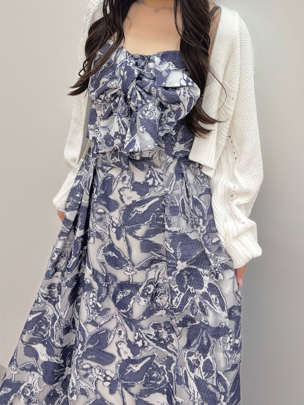 ブルー系のワンピース、ブラウン系のブーツ、ホワイト系のカーディガン/ボレロを着用したレディースの秋コーディネートの6枚目の写真