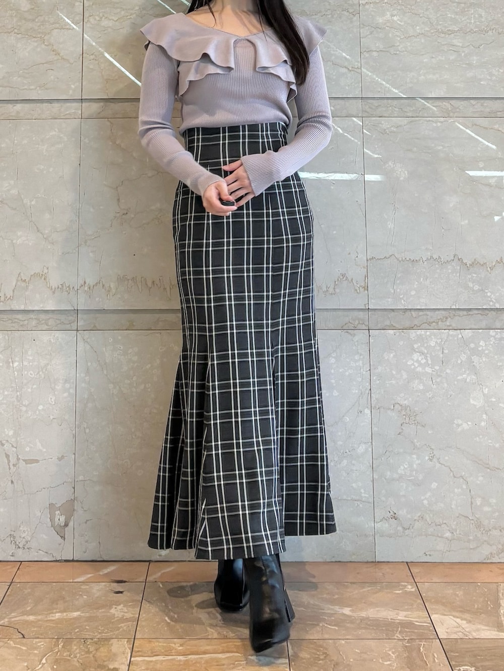 ピンク系のハンドバッグ、ブラック系のブーツ、その他のスカートを着用したレディースの冬コーディネートの3枚目の写真