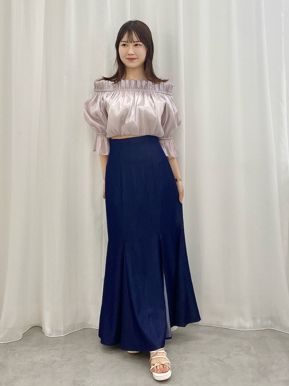 ブルー系のスカート、ホワイト系のサンダル、パープル系のシャツ/ブラウスを着用したレディースの春コーディネートの2枚目の写真