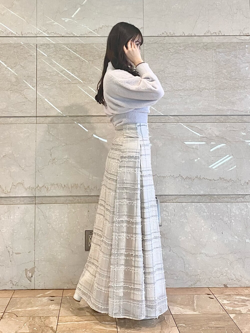 シルバー系のハンドバッグ、ホワイト系のブーツ、パープル系のニット/セーターを着用したレディースの冬コーディネートの3枚目の写真