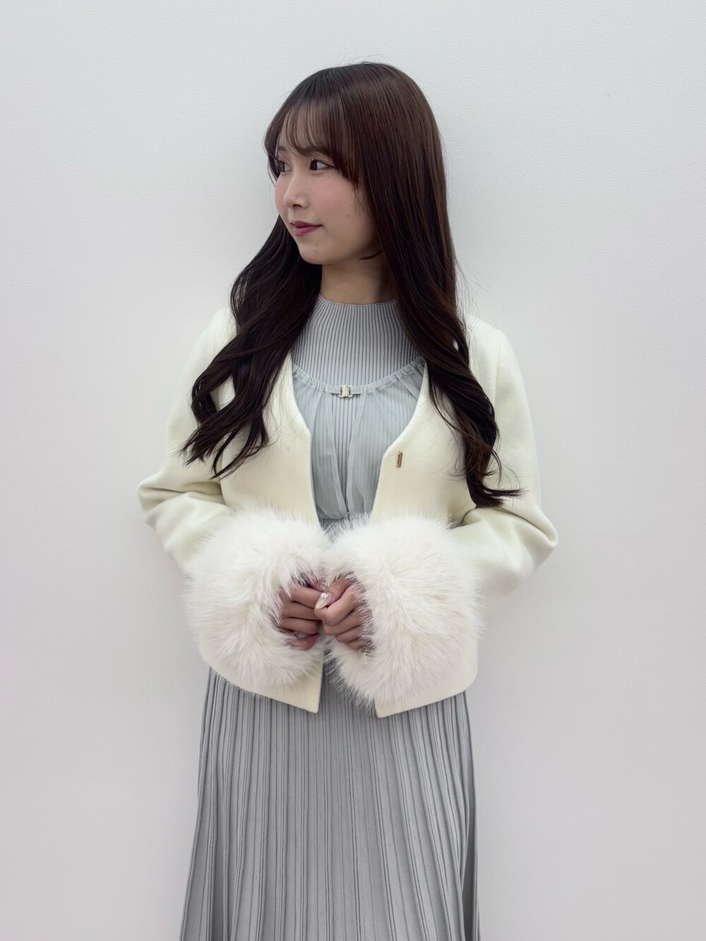 ブラック系のブーツ、ホワイト系のその他アウター、グレー系のワンピースを着用したレディースの冬コーディネートの6枚目の写真