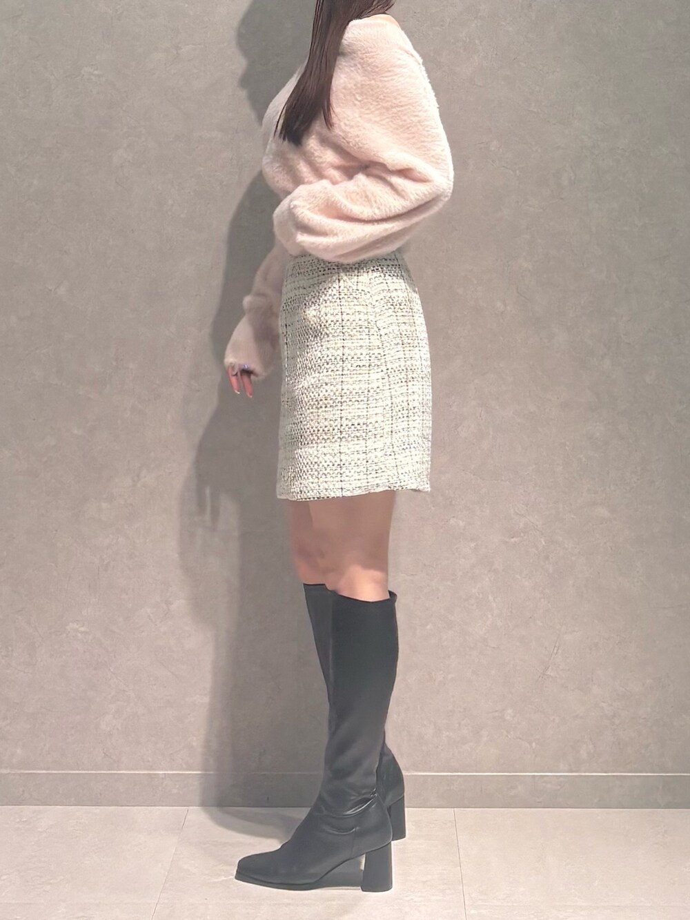 ホワイト系のスカート、ピンク系のニット/セーター、ブラック系のブーツを着用したレディースの秋コーディネートの4枚目の写真