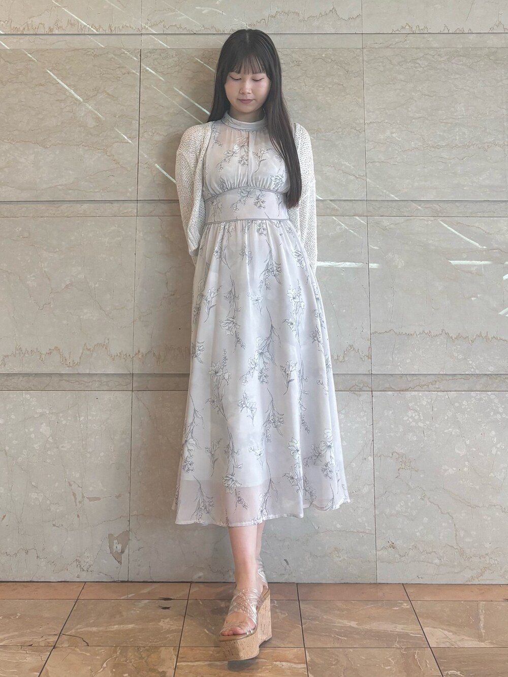 グレー系のワンピース、その他のサンダル、ホワイト系のカーディガン/ボレロを着用したレディースの夏コーディネートの2枚目の写真