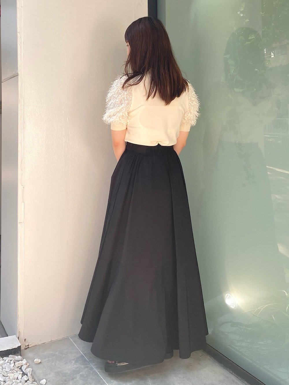 ブラック系のショルダーバッグ、ブラック系のサンダル、ブラック系のスカートを着用したレディースの夏コーディネートの3枚目の写真