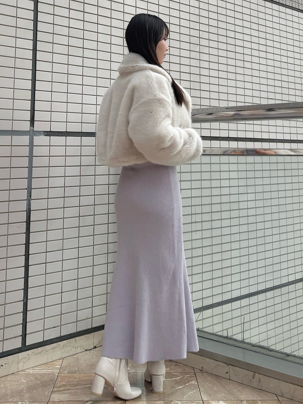 パープル系のワンピース、ホワイト系のブーツ、ホワイト系のその他アウターを着用したレディースの冬コーディネートの4枚目の写真