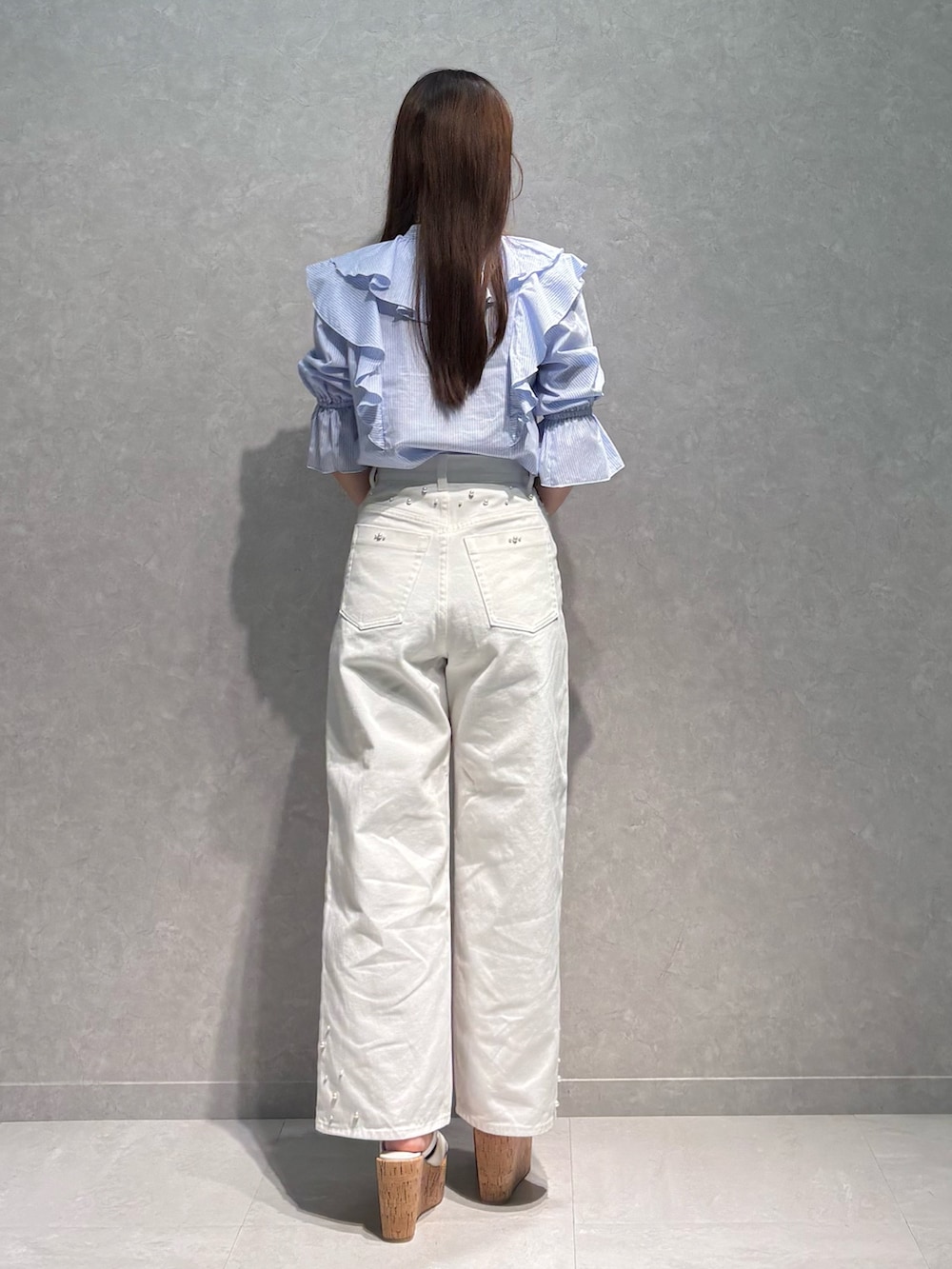 ホワイト系のデニムパンツ、ブルー系のシャツ/ブラウス、ベージュ系のハンドバッグを着用したレディースの春コーディネートの5枚目の写真