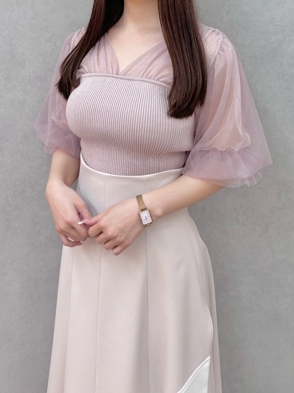 ベージュ系のスカート、ホワイト系のサンダル、ピンク系のニット/セーターを着用したレディースの春コーディネートの5枚目の写真