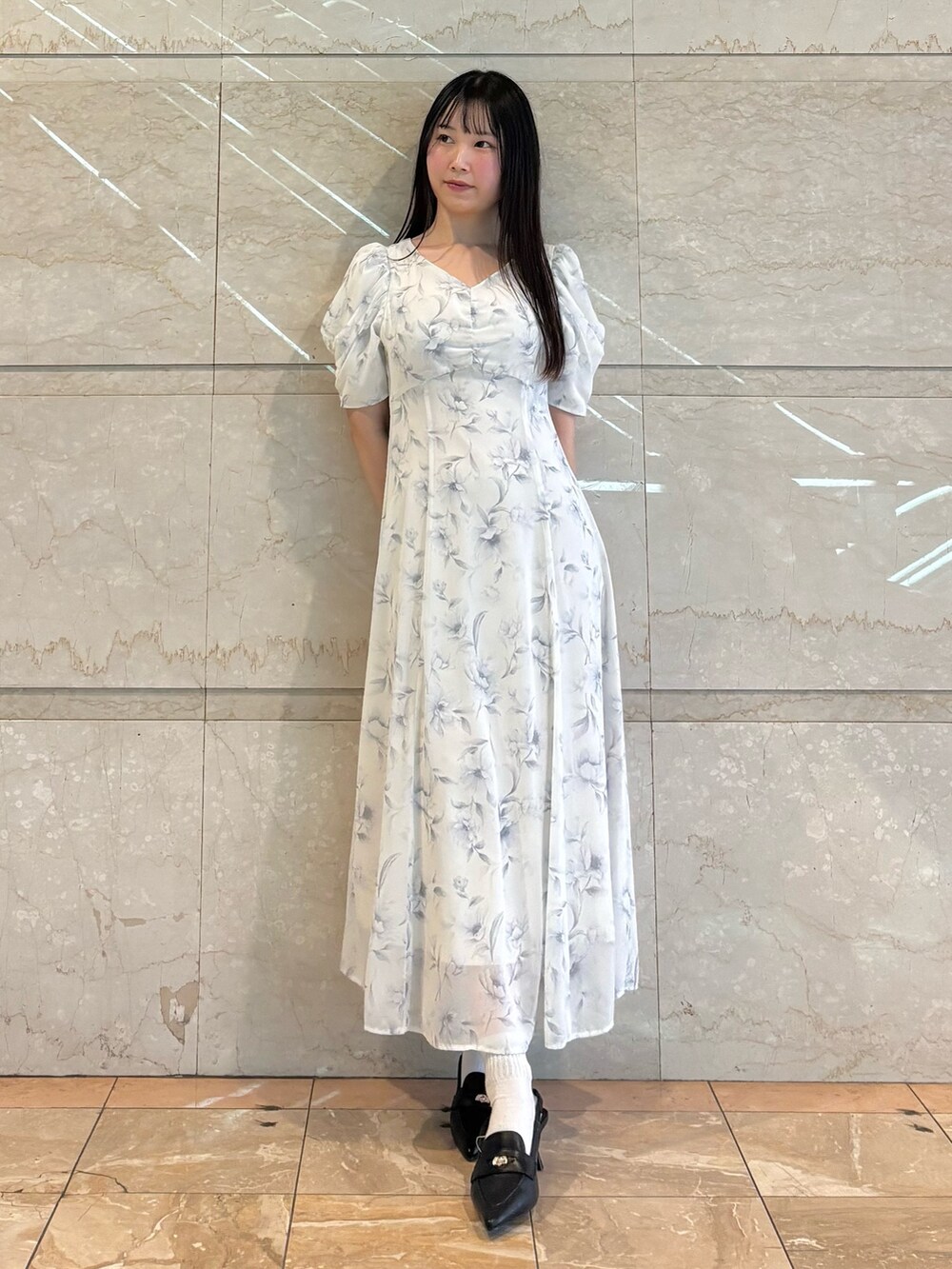 ホワイト系のワンピース、ブラック系のパンプスを着用したレディースの春コーディネートの2枚目の写真