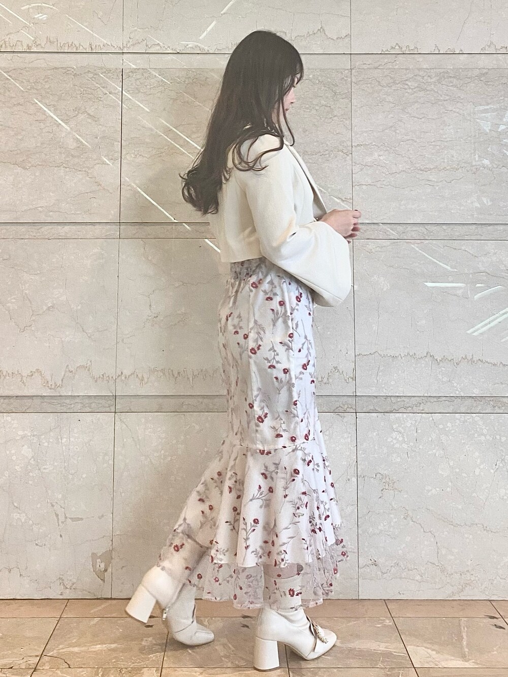 レッド系のワンピース、ホワイト系のブーツ、ホワイト系のテーラードジャケットを着用したレディースの春コーディネートの3枚目の写真