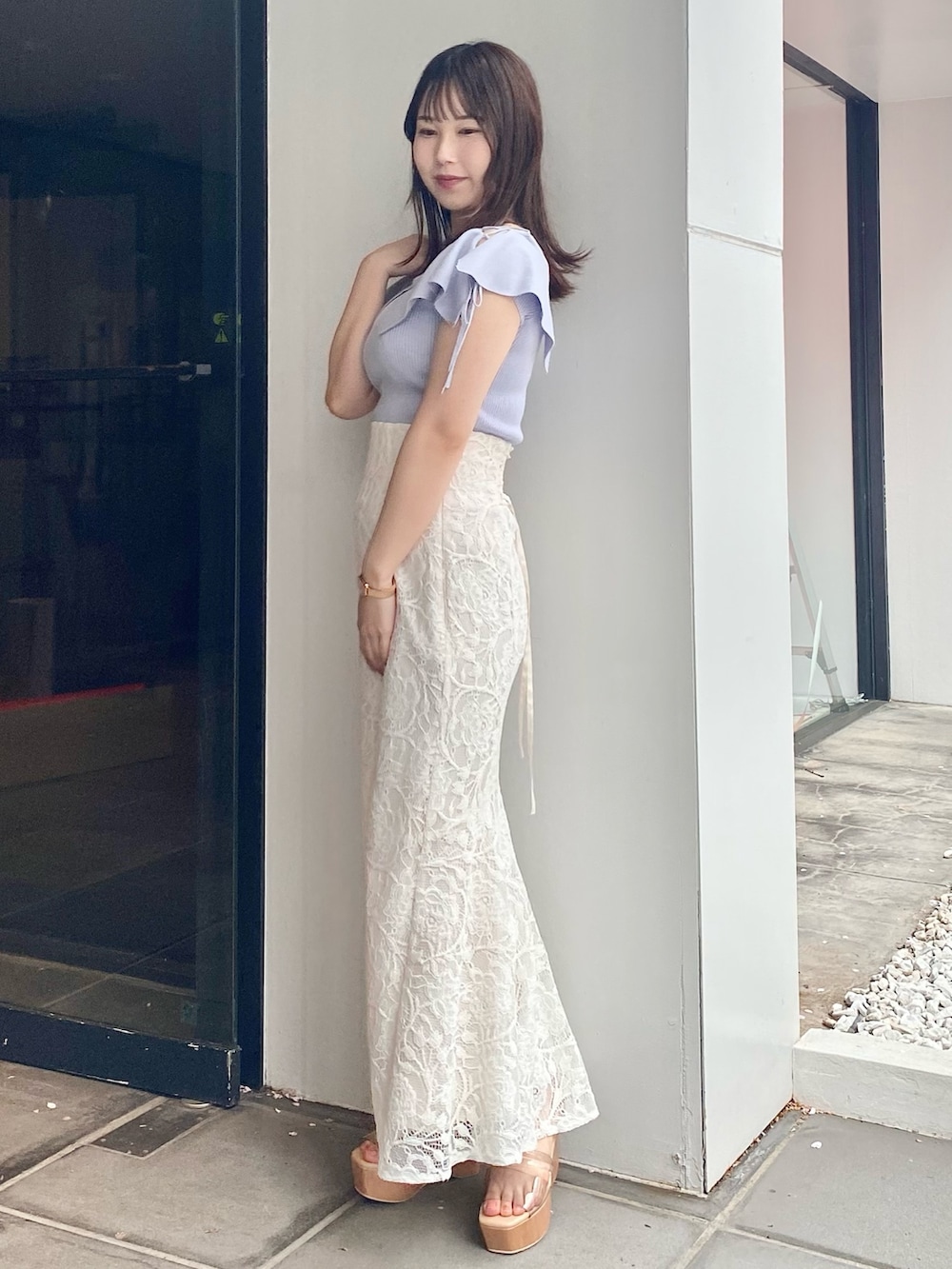 ホワイト系のスカート、グレー系のサンダル、ブルー系のニット/セーターを着用したレディースの春コーディネートの2枚目の写真