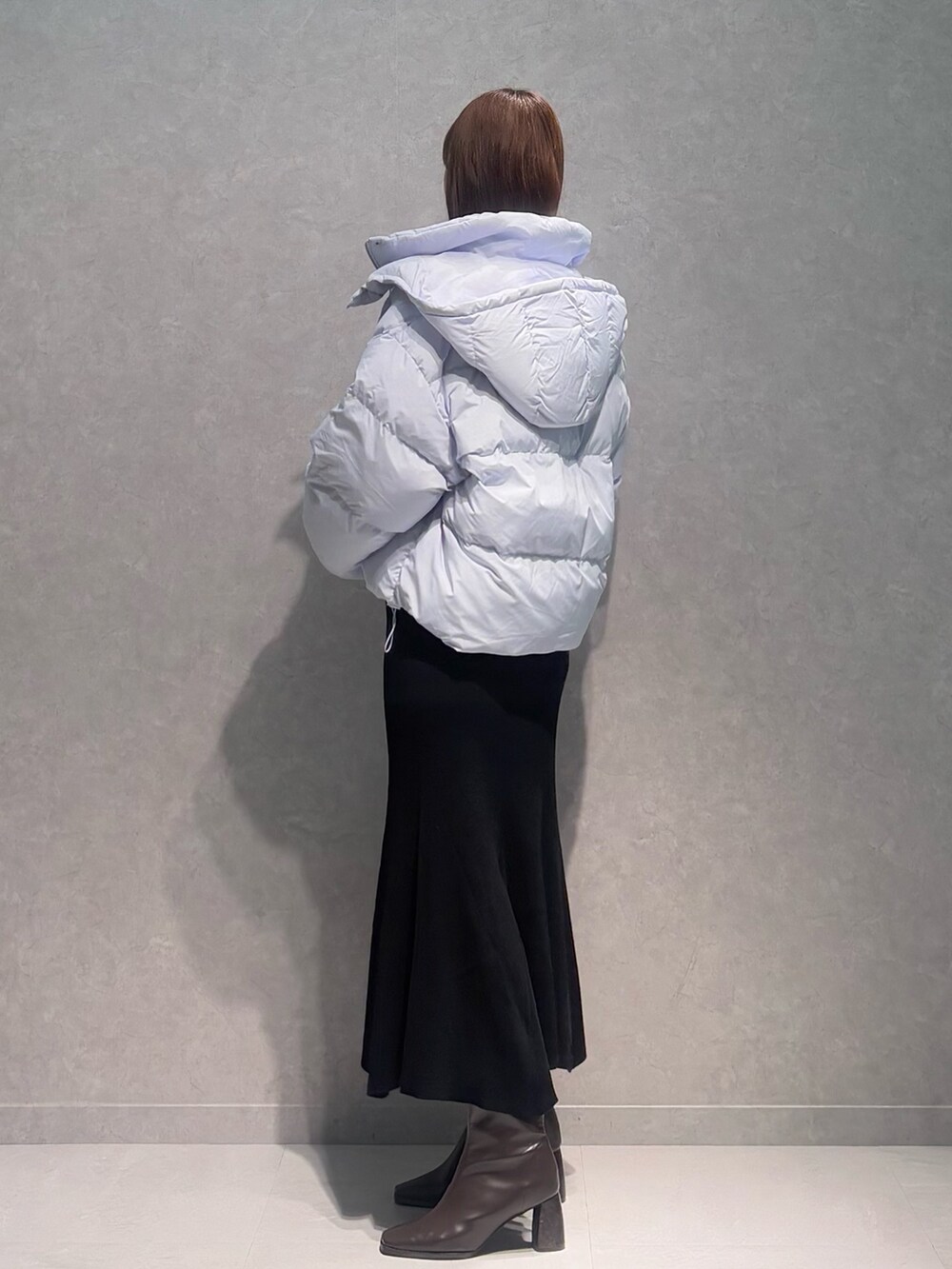 ブラック系のワンピース、ブルー系のダウンジャケット/コート、ブラウン系のブーツを着用したレディースの冬コーディネートの3枚目の写真