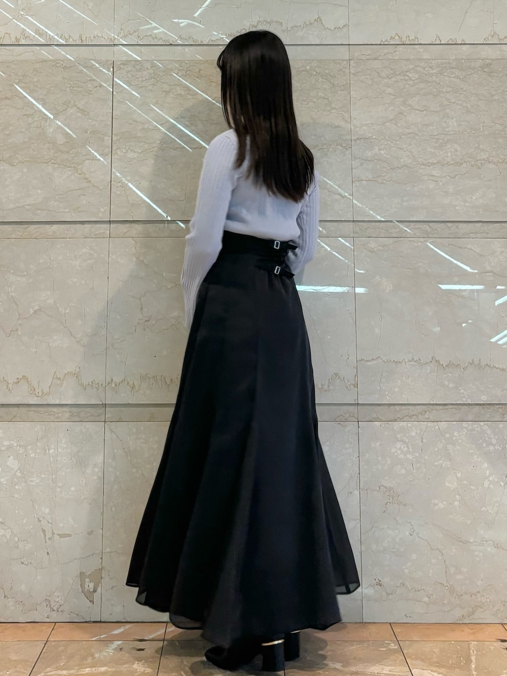 ブラック系のスカート、ブラック系のブーツ、ブルー系のニット/セーターを着用したレディースの秋コーディネートの4枚目の写真