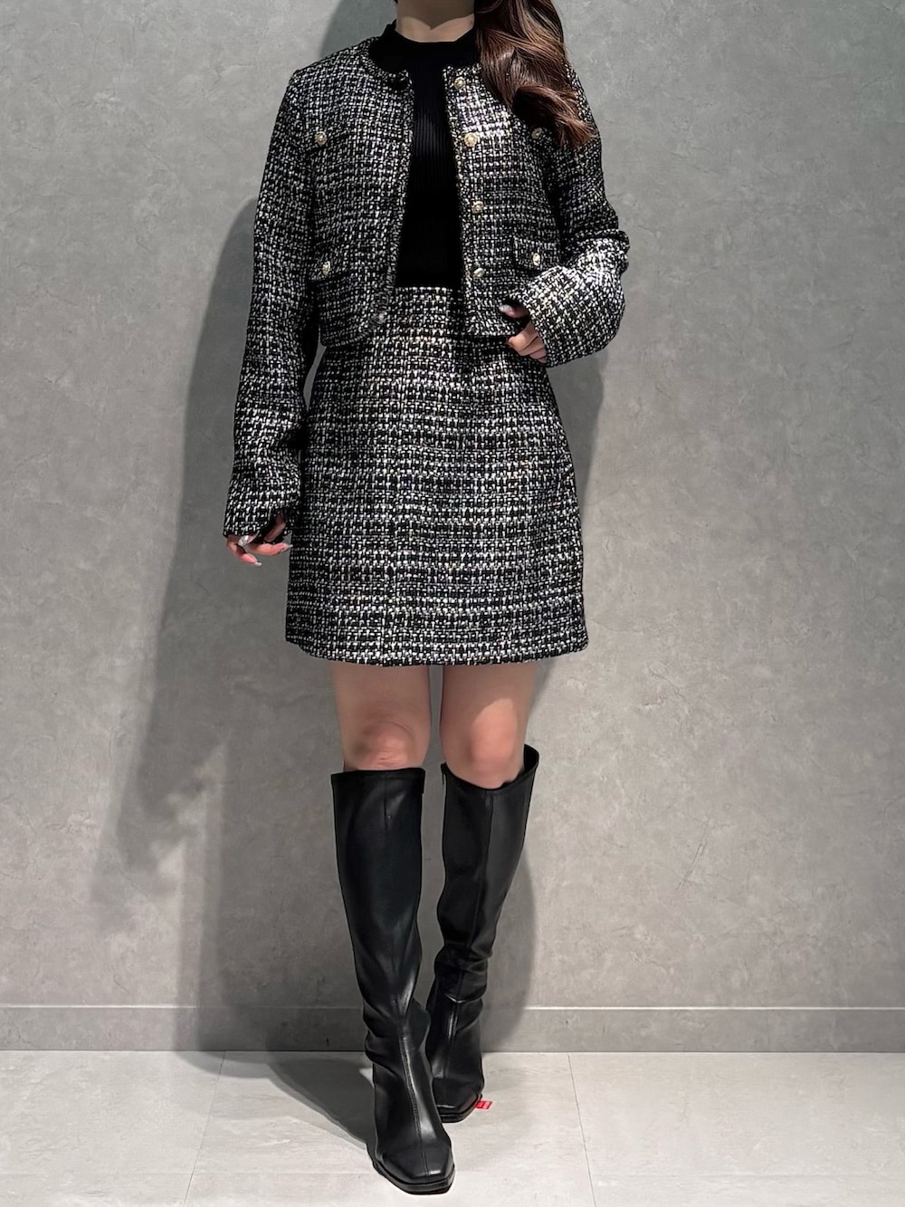 ブラック系のスカート、ブラック系のニット/セーター、ブラック系のテーラードジャケットを着用したレディースの春コーディネートの3枚目の写真