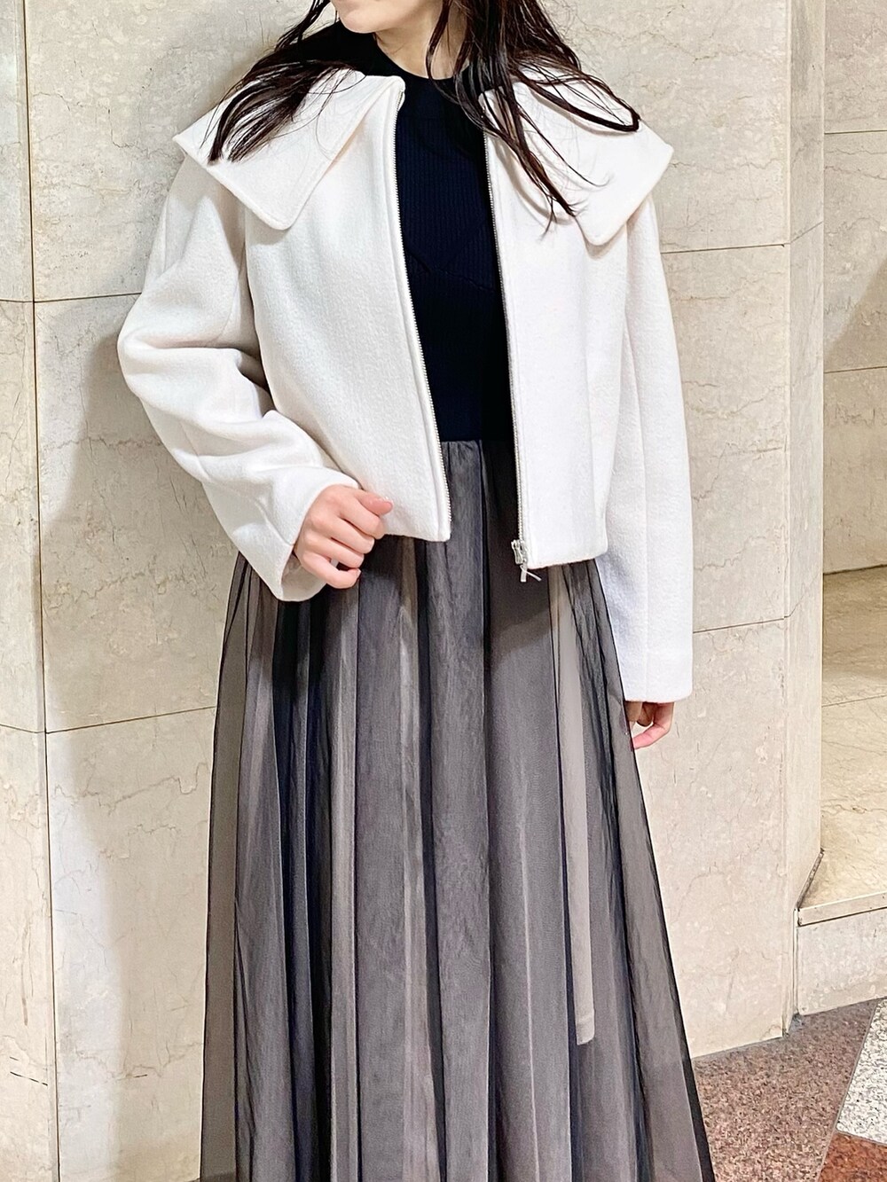 ブラック系のワンピース、ホワイト系のその他アウター、ブラック系のブーツを着用したレディースの秋コーディネートの4枚目の写真