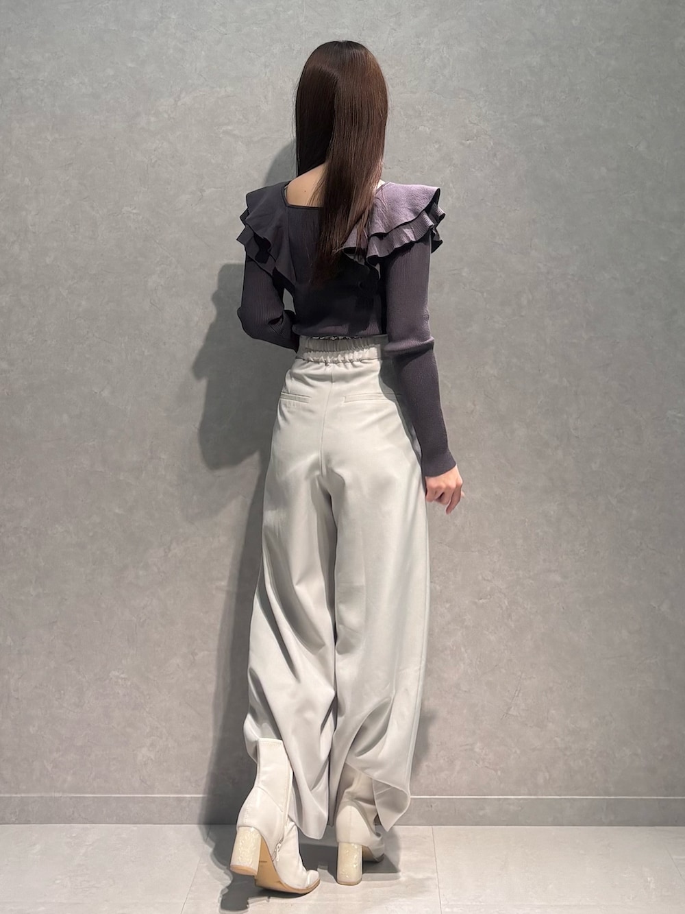 ベージュ系のその他パンツ、グレー系のニット/セーター、ホワイト系のブーツを着用したレディースの冬コーディネートの5枚目の写真