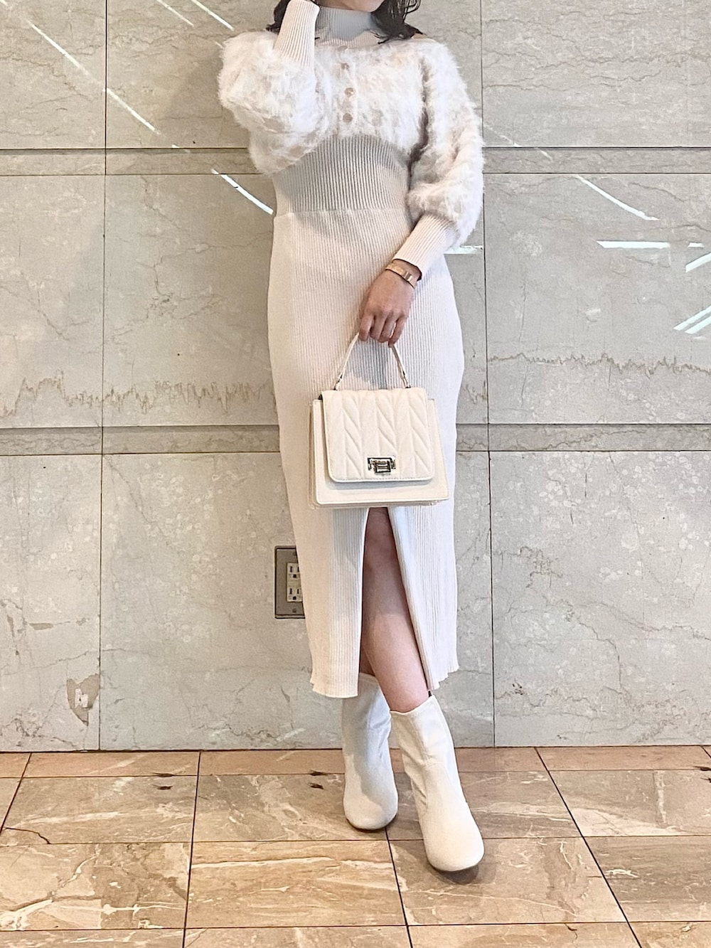 ベージュ系のワンピース、ホワイト系のブーツ、ホワイト系のショルダーバッグを着用したレディースの冬コーディネートの2枚目の写真